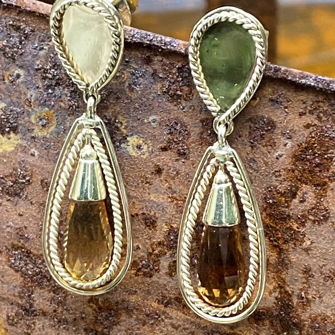 Elegante goldene Ohrringe mit tropfenförmigen Steinen.