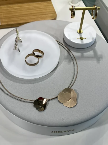Schmuckdisplay mit einer Halskette, Ringen und Ohrringen in goldfarbenem Design.