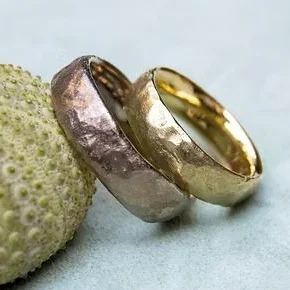 Zwei handgefertigte Ringe, einer in Graugold und der andere in Gelbgold.