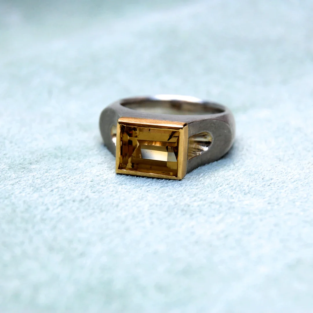 Silberner Ring mit quadratischem, gelbem Rauchquarz in der Mitte.