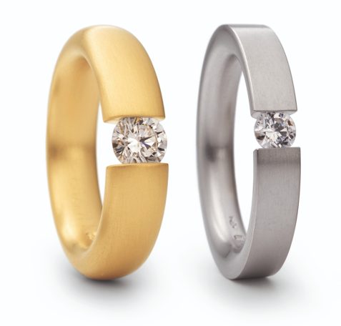 Zwei Ringe, einer Gelbgold, der andere  Graugold mit gespannten Brillanten