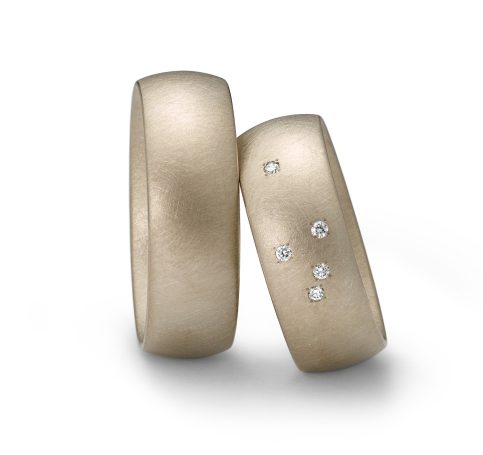 Eheringe aus sandfarbenem Gold mit eingelassenen Diamanten.