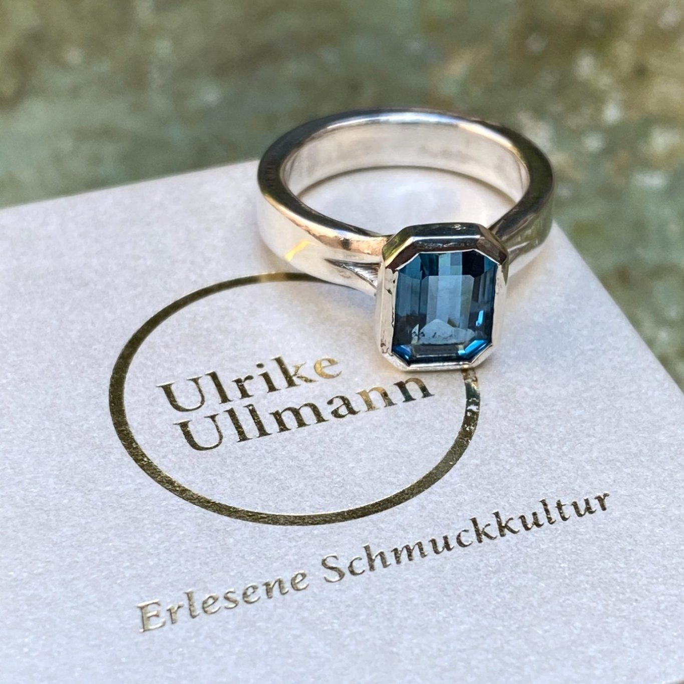 Silberner Ring mit einem blauen, rechteckigen Aquamarin und einer eleganten Schatulle.