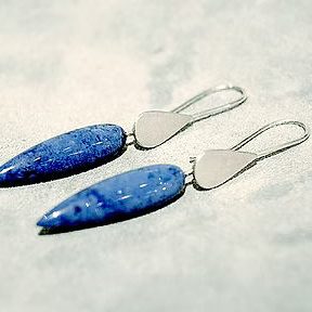 Blaue Ohrringe mit länglicher Form und silbernen Haken.