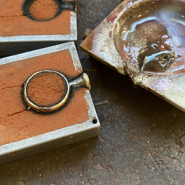 Sandgussform mit Goldring und Schmelztiegel