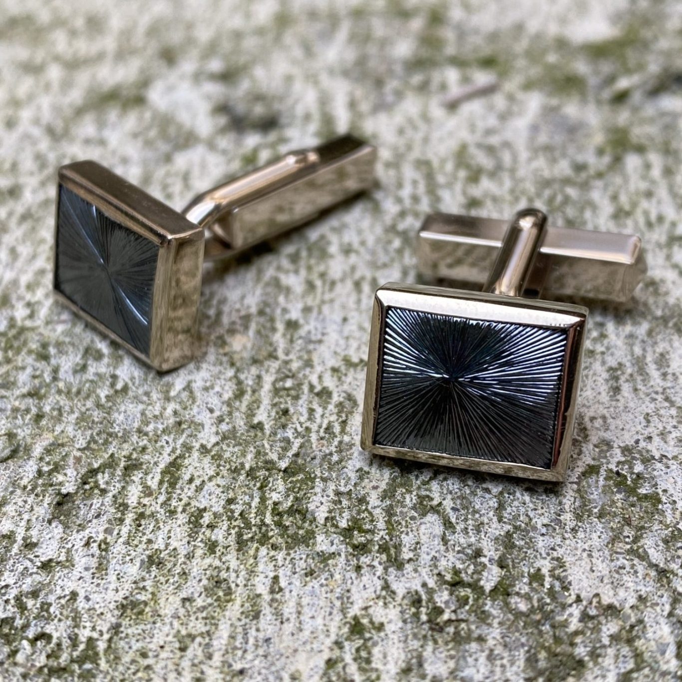 Zwei quadratische Manschettenknöpfe aus Graugold mit einem glänzenden, schwarz-grauen Hämatit.