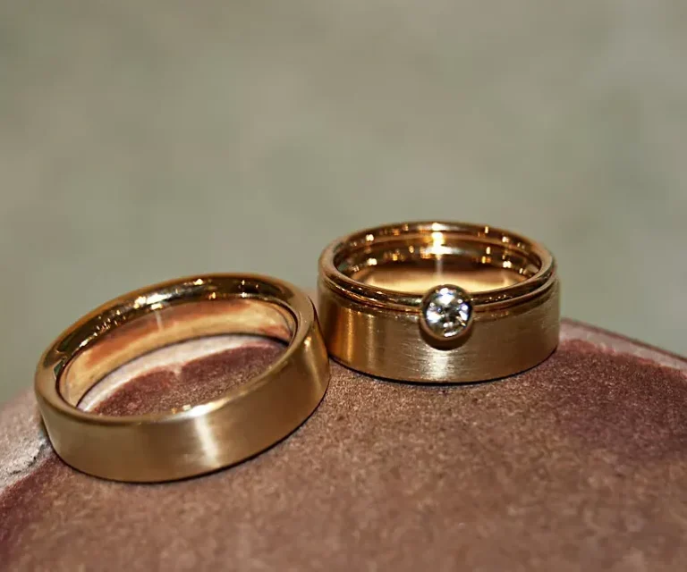 Vorsteckringe Zwei goldene Trauringe mit einem Vorsteckring mit einem kleinen Diamanten.