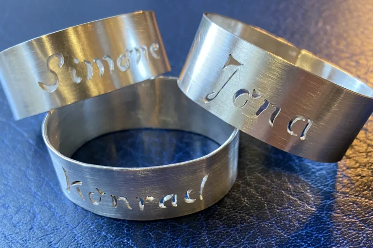 Serviettenringe Drei Serviettenringe aus Silber mit eingravierten Namen: Simone, Jona und Konrad.